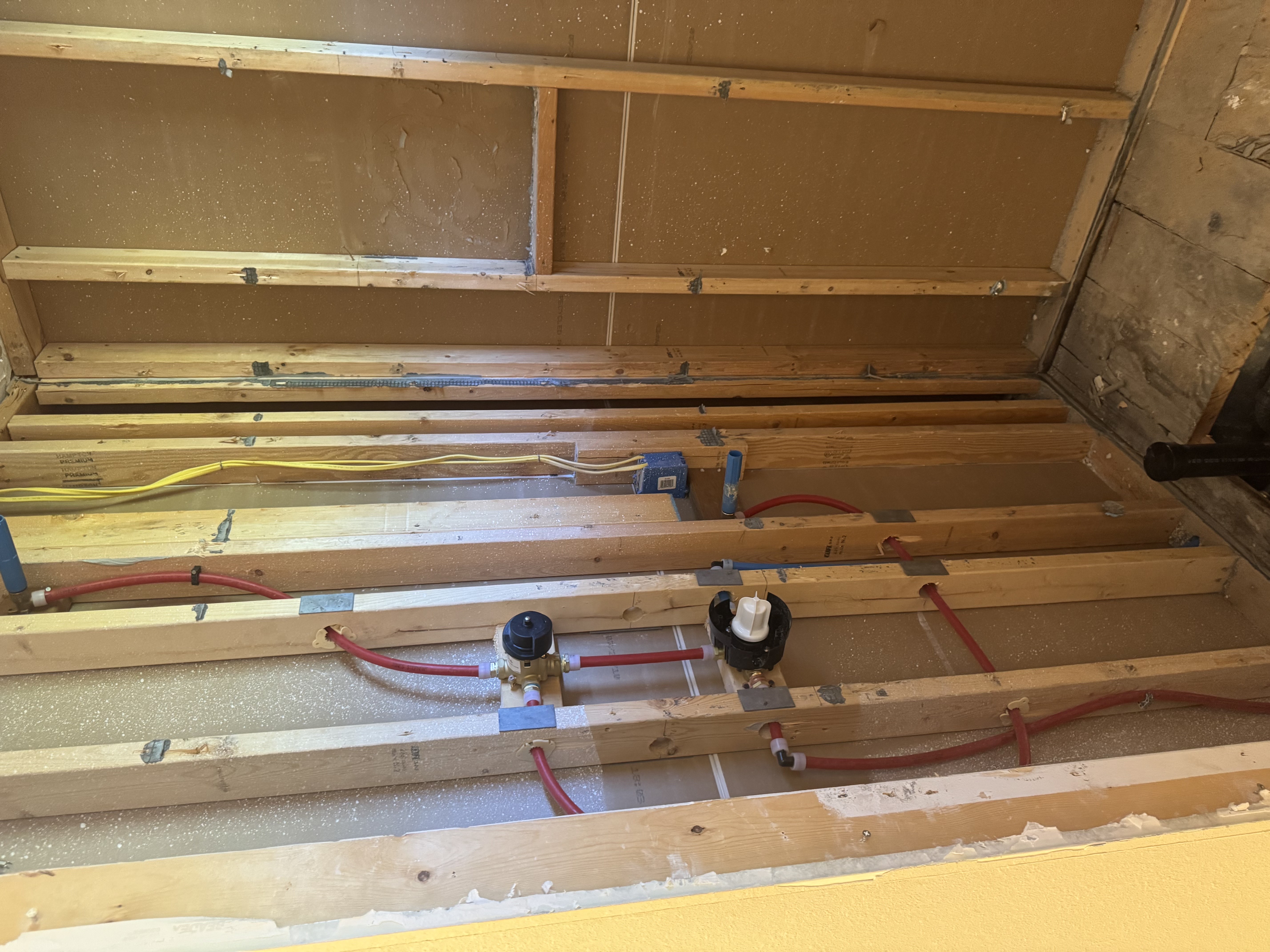 Interior plumbing rough-in work with PEX water lines in wall framing